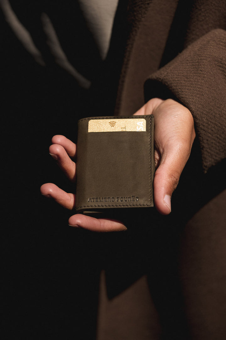 Portefeuille compact en cuir pleine fleur THASOS coloris bronze, tenu en main n°1 – Ateliers Fourès