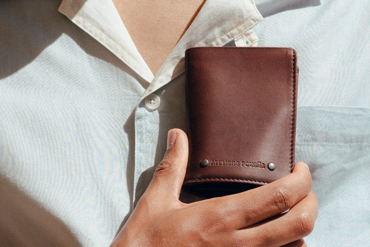 Portefeuille compact en cuir pleine fleur PÉGASE coloris cognac, tenu en main n°1 – Ateliers Fourès