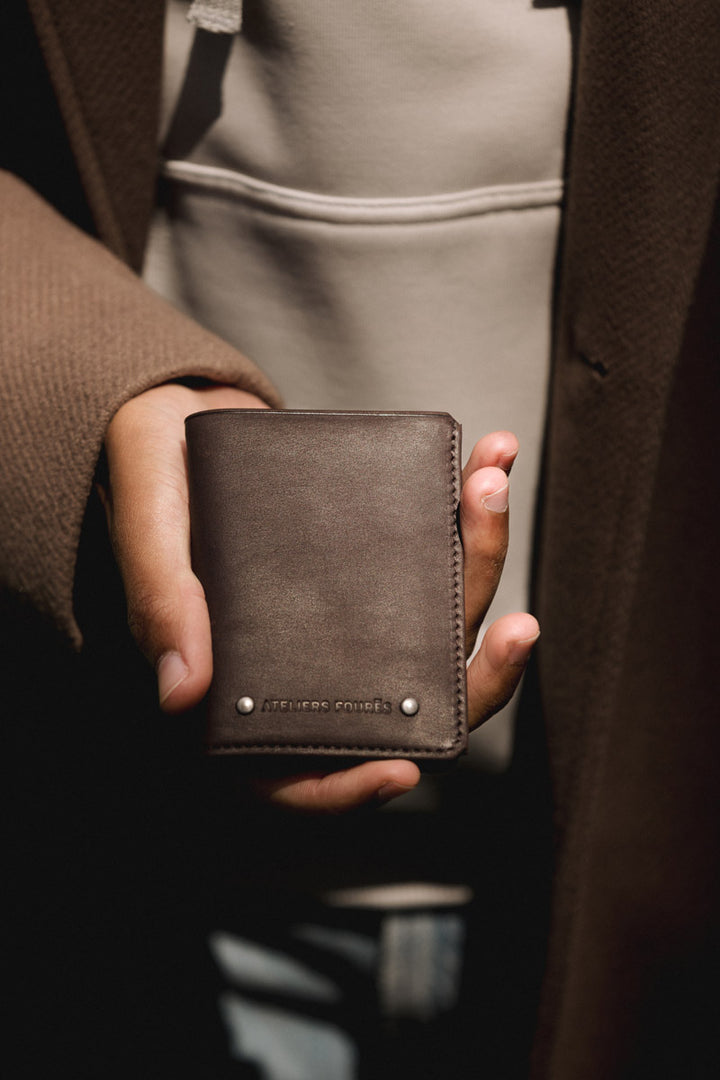 Portefeuille compact en cuir pleine fleur PÉGASE coloris mustang, tenu en main n°1 – Ateliers Fourès
