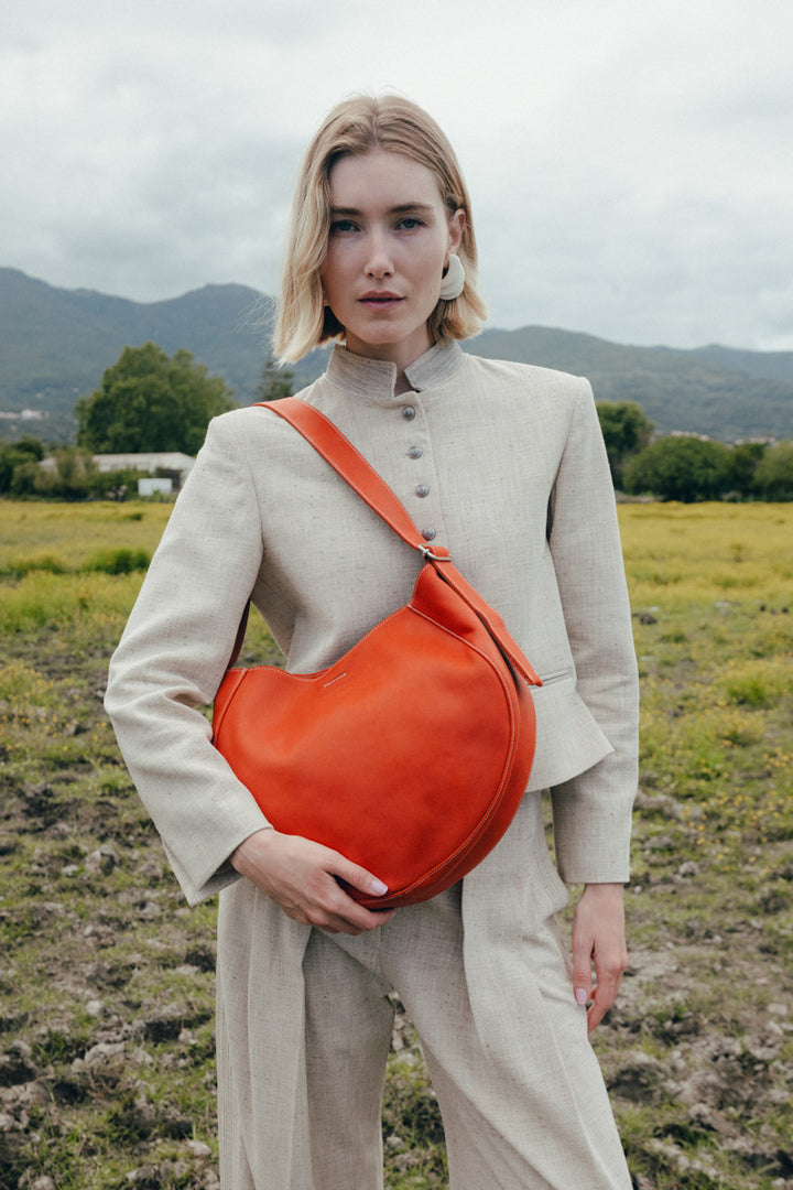 Sac à main en cuir pleine fleur ETNA coloris orange confit, porté à l’épaule n°1 – Ateliers Fourès