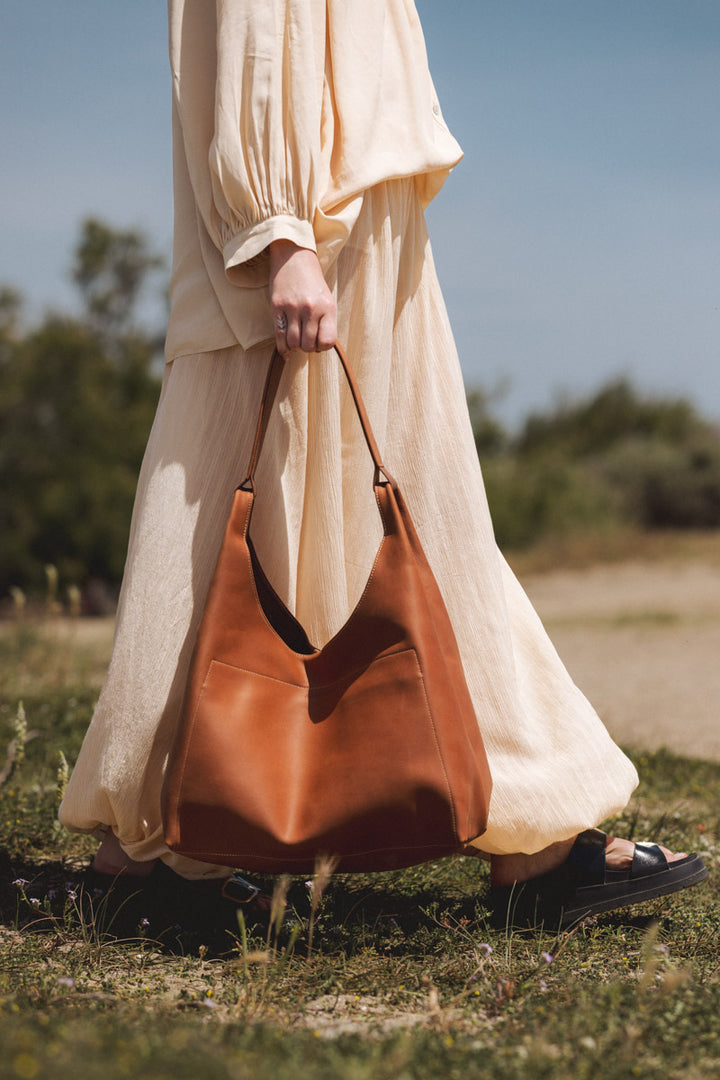 Sac de voyage en cuir pleine fleur AMAZONE coloris fauve, porté n°1 – Ateliers Fourès