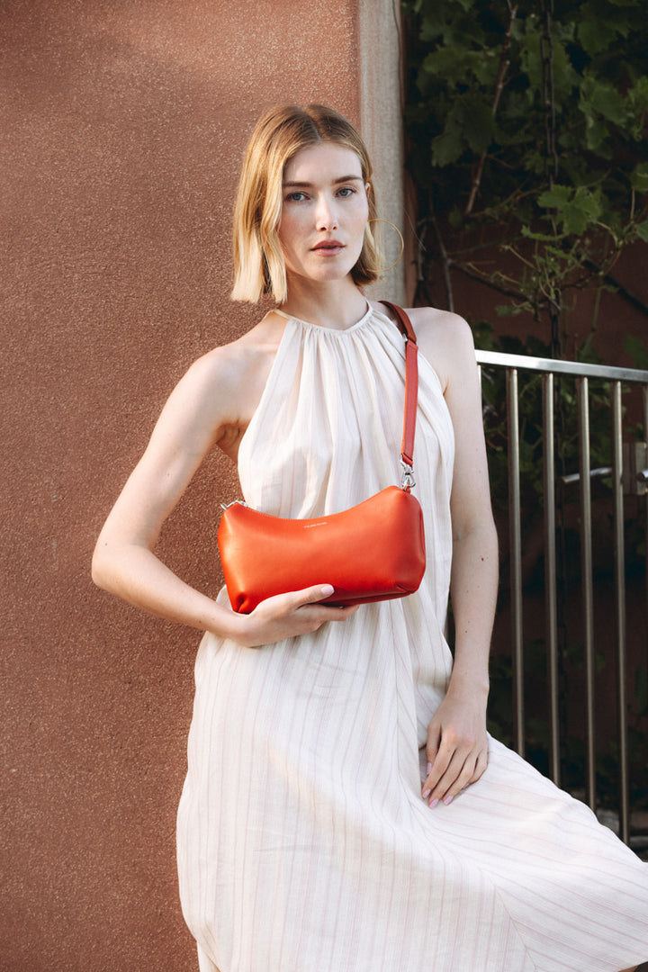 Sac à main en cuir pleine fleur HÉCATE coloris orange, porté à l’épaule n°1 – Ateliers Fourès