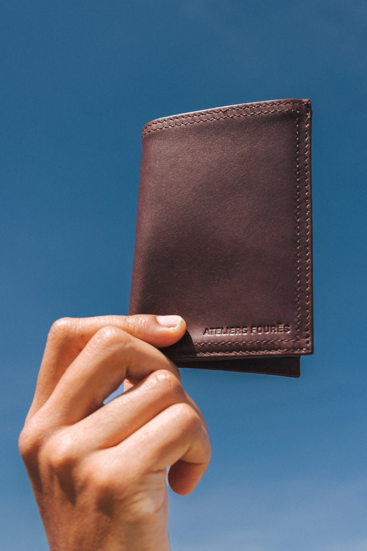 Portefeuille medium en cuir pleine fleur PLATON coloris cafe, tenu en main n°1 – Ateliers Fourès