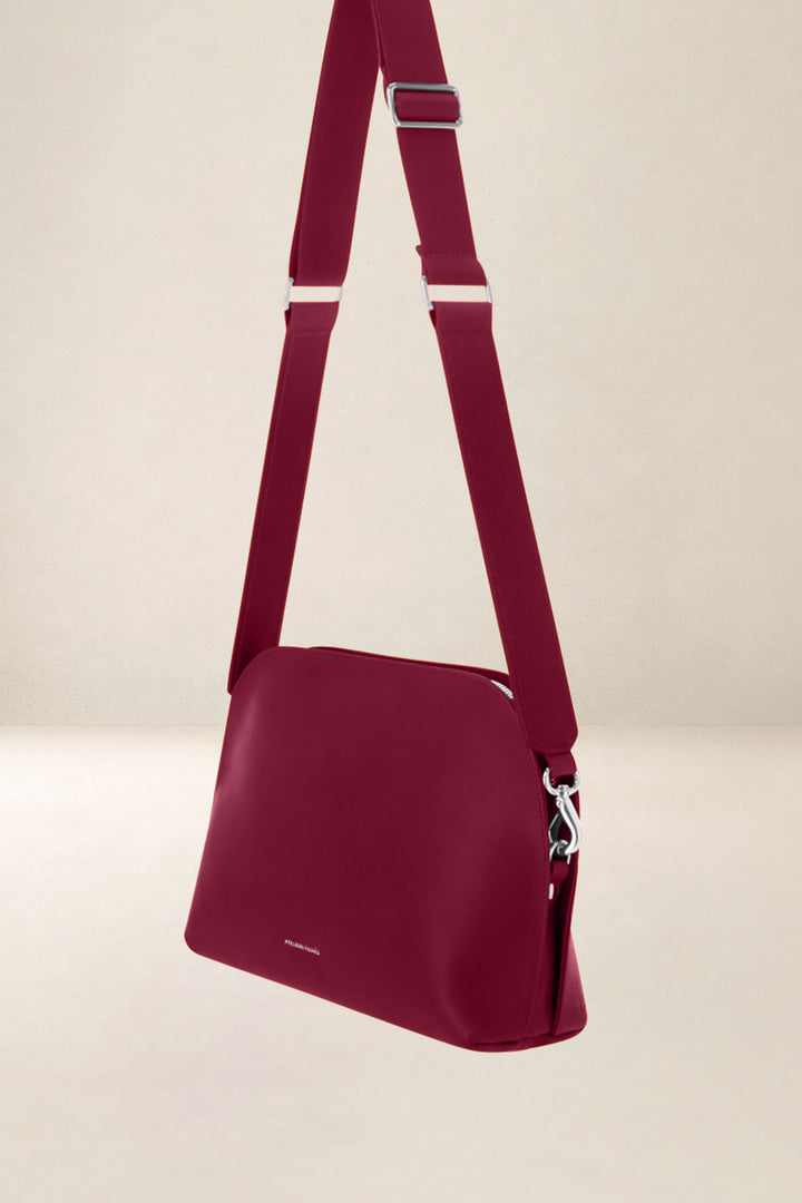 Sac bandoulière en cuir pleine fleur ODYSSÉE coloris pourpre, vue de profil n°1 – Ateliers Fourès