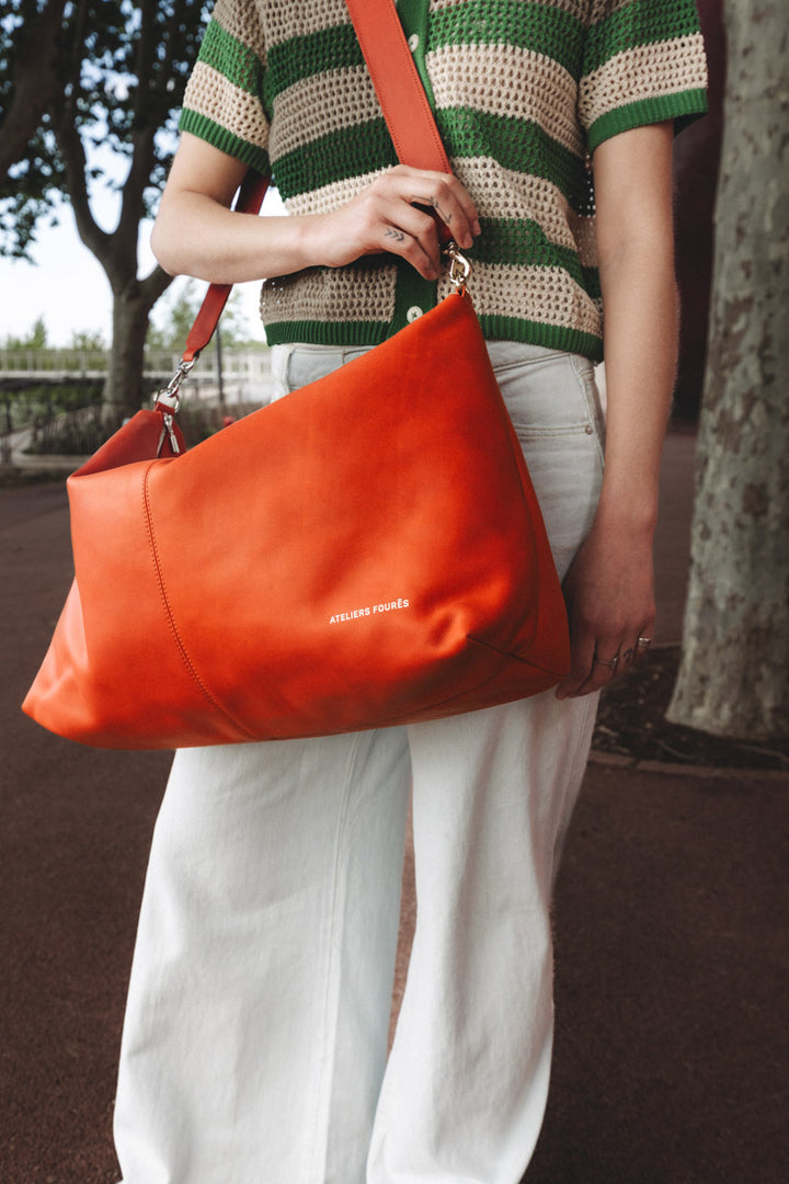 Sac de voyage en cuir pleine fleur ILIADE coloris orange confit, porté en bandoulière n°1 – Ateliers Fourès