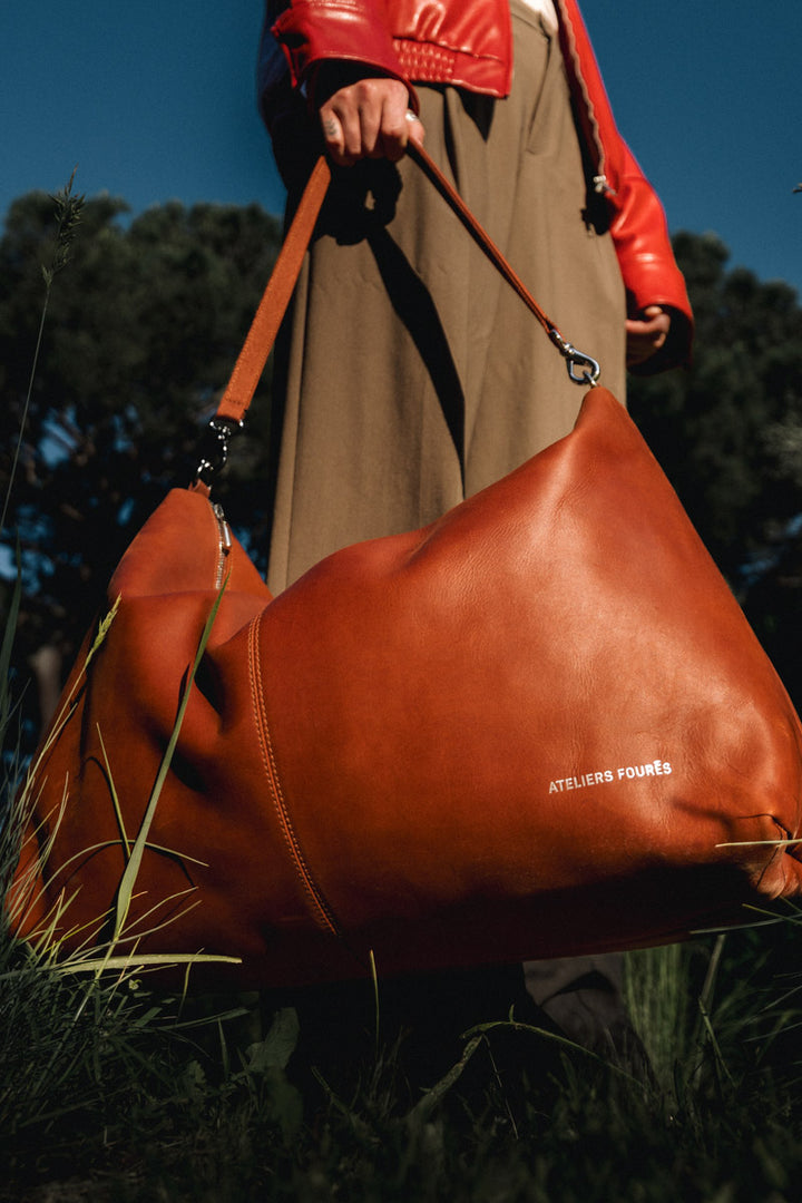 Sac de voyage en cuir pleine fleur ILIADE coloris fauve, porté en bandoulière n°1 – Ateliers Fourès