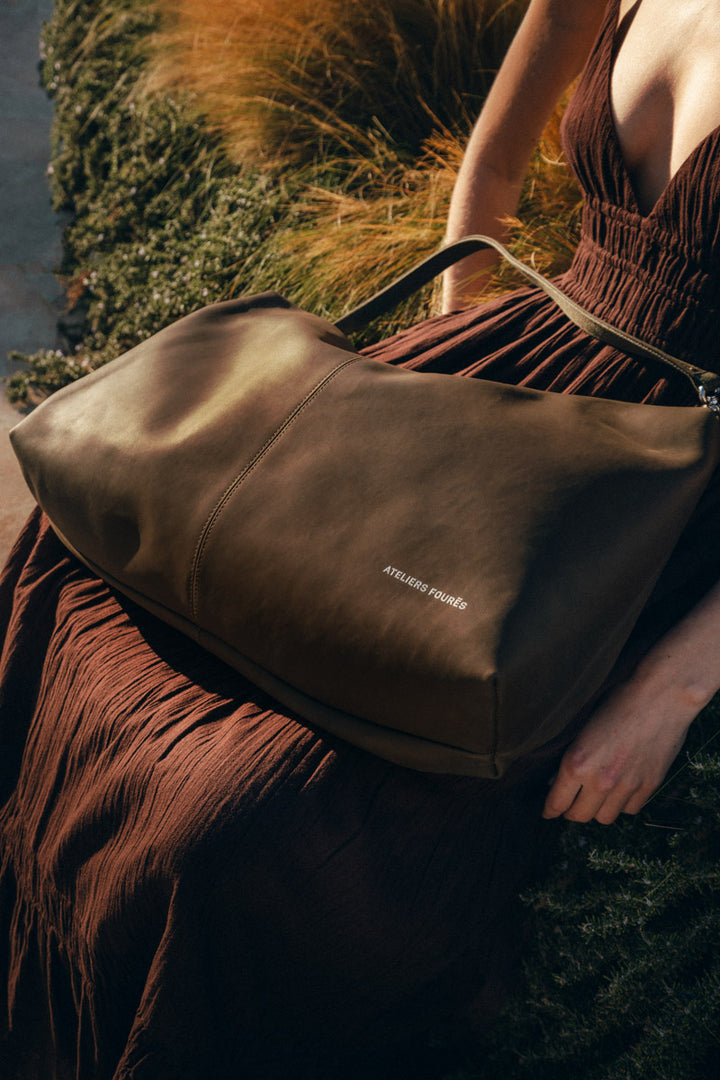 Sac de voyage en cuir pleine fleur ILIADE coloris kaki, porté en bandoulière – Ateliers Fourès