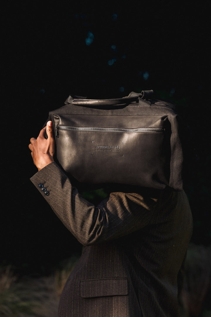 Sac de voyage en cuir pleine fleur ARISTOTE coloris noir, porté – Ateliers Fourès