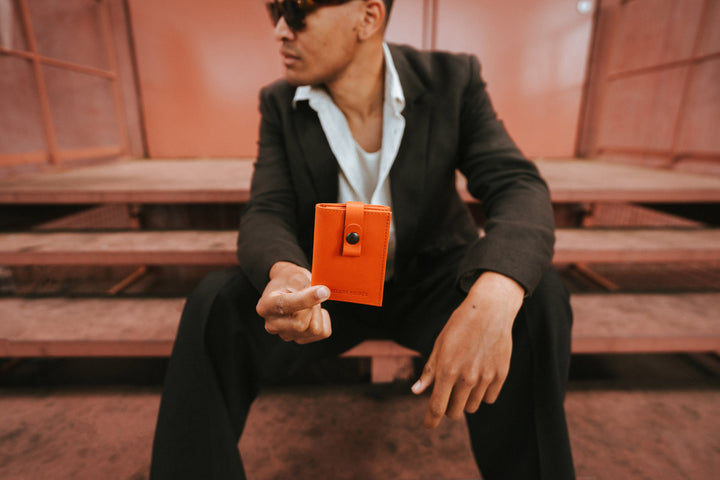Petite maroquinerie en cuir pleine fleur ARCHIMÈDE coloris orange, tenu en main n°1 – Ateliers Fourès